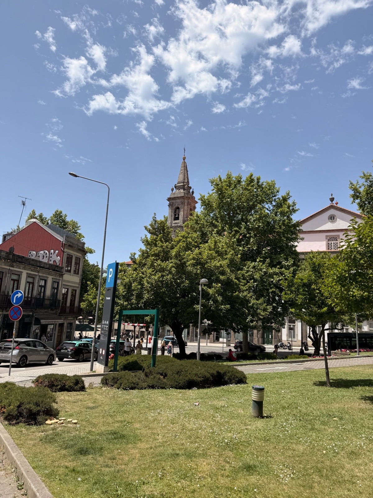 Plein in Porto met kerk en klokkentoren, blauwe lucht