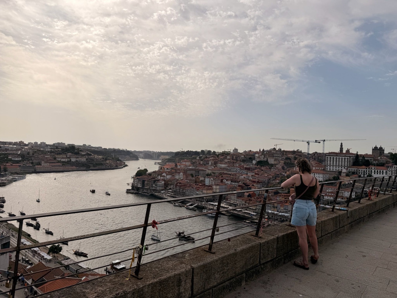 Sophie kijkt vanaf de bovenste etage van de Dom Luís I-brug over de Douro en Ribeira